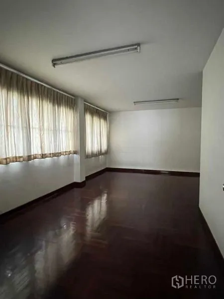 Factory for rent in Bang Na, Bangkok - Private office room with curtain-lined windows and glossy wooden floor.