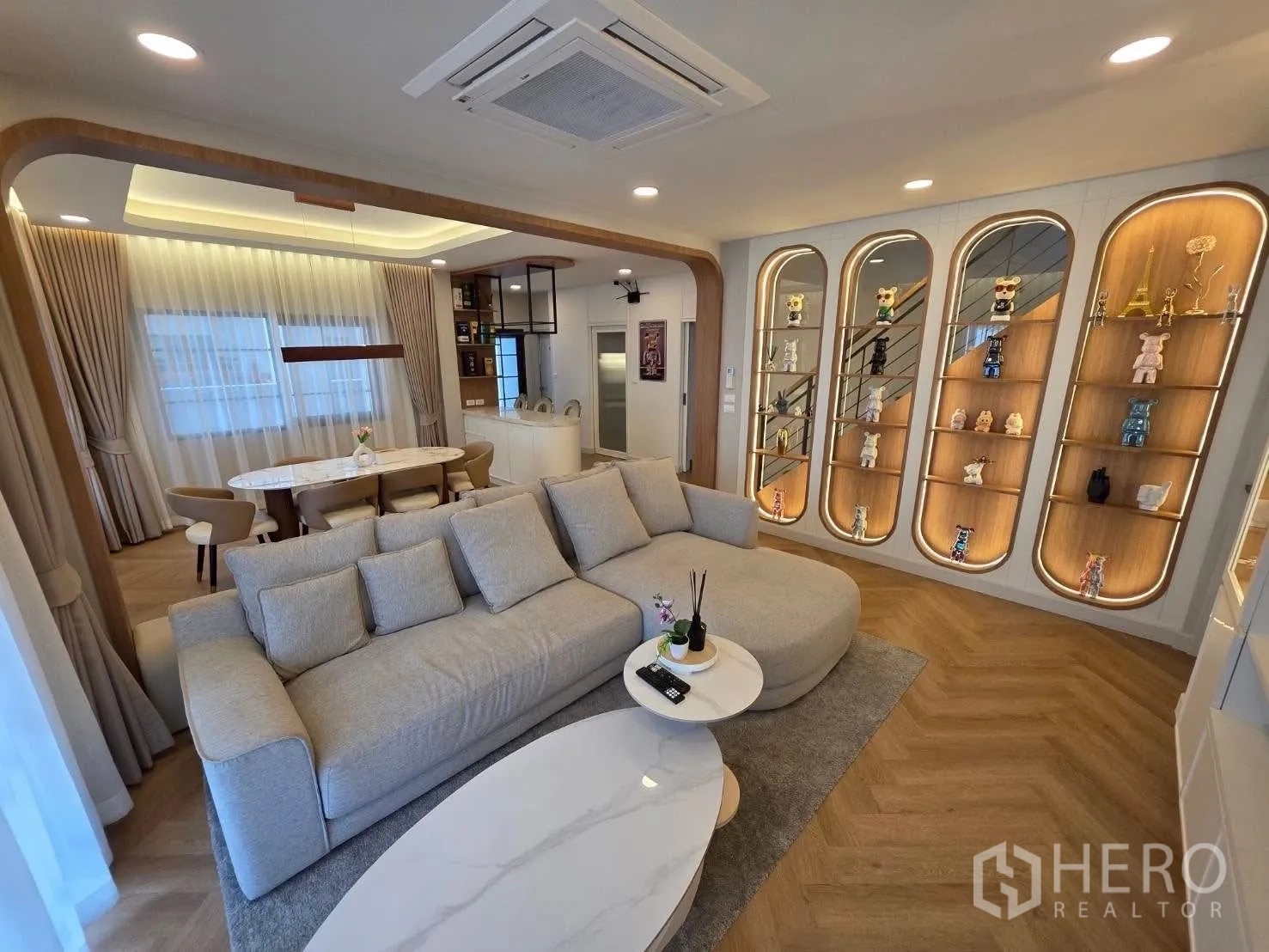 Detached House for rent or sale in Bang Phli, Samut Prakan - Large sofa in airy lounge with floor-to-ceiling shelving displays.
