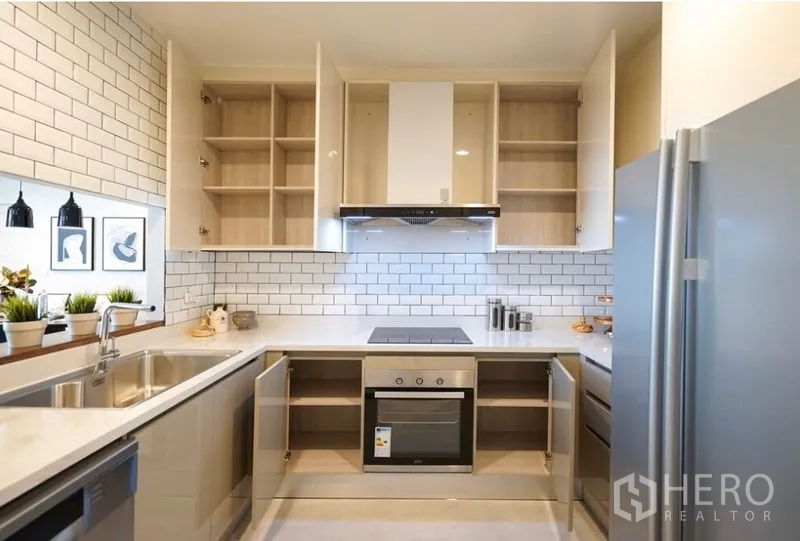 คอนโด ให้เช่าในWatthana, Bangkok - ครัวรูปตัวยูสไตล์โมเดิร์น ผนังกระเบื้องซับเวย์ เตาแม่เหล็กไฟฟ้า เตาอบ และตู้เก็บของเปิด