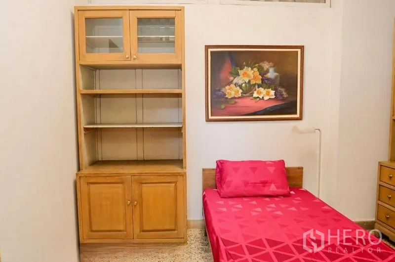 อพาร์ทเมนท์ ให้เช่าในPathum Wan, Bangkok - ห้องนอนเดี่ยวอบอุ่น ชุดเครื่องนอนสีชมพู ตู้ชั้นไม้ และภาพดอกไม้