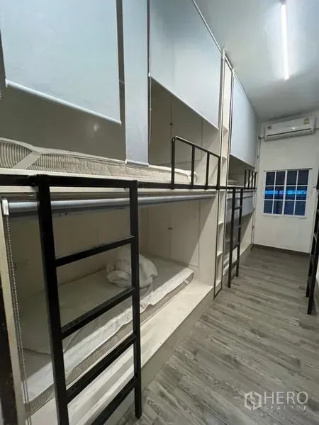 อาคารพาณิชย์ ให้เช่าหรือขายในWatthana, Bangkok - ห้องนอนรวมยาวพร้อมเตียงสองชั้นหลายเตียง บันได และเครื่องปรับอากาศ