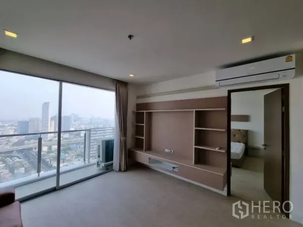 คอนโด ให้เช่าในWatthana, Bangkok - ห้องนั่งเล่นพร้อมผนังทีวีบิลต์อิน แอร์ และประตูกระจกออกระเบียงวิวเมือง พร้อมประตูไปห้องนอน