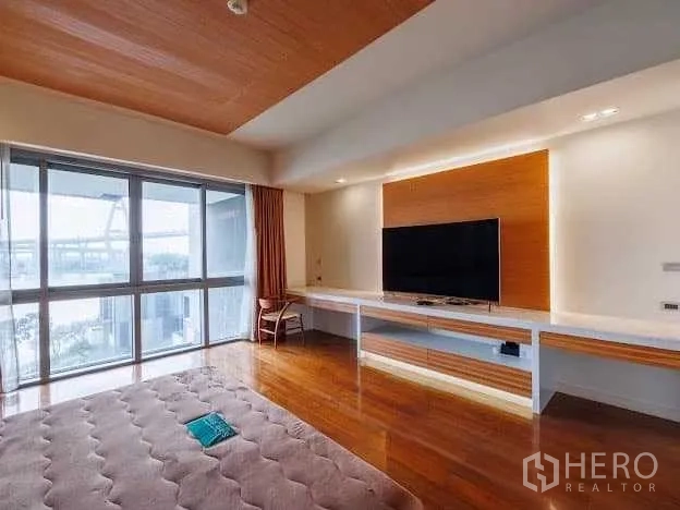 Condominium for sale in Yan Nawa, Bangkok - Bedroom media wall with mounted TV, long desk and floor‑to‑ceiling windows with river outlook.