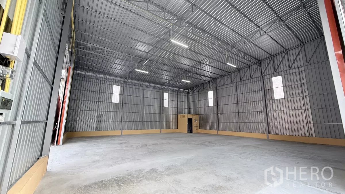 Warehouse for rent in Wang Thonglang, Bangkok - Bright steel-clad warehouse hall with windows and polished concrete flooring.