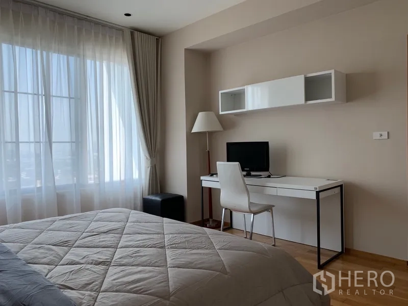 公寓 出租在Khlong Toei, Bangkok - 卧室设大窗与纱帘，配学习书桌和壁挂置物格。