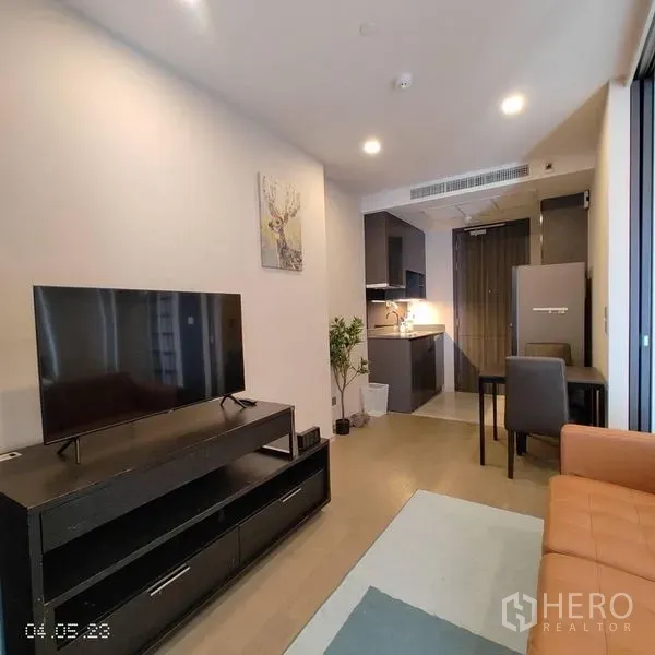 Condominium for rent in Watthana, Bangkok - Cozy living room with TV console, dining set and fitted kitchen.