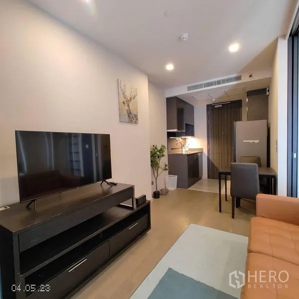 Condominium for rent in Watthana, Bangkok - Cozy living room with TV console, dining set and fitted kitchen.