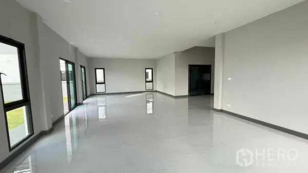 Detached House for sale in Bang Phli, Samut Prakan - Spacious open-plan living area with glossy tiles and sliding doors to the garden.