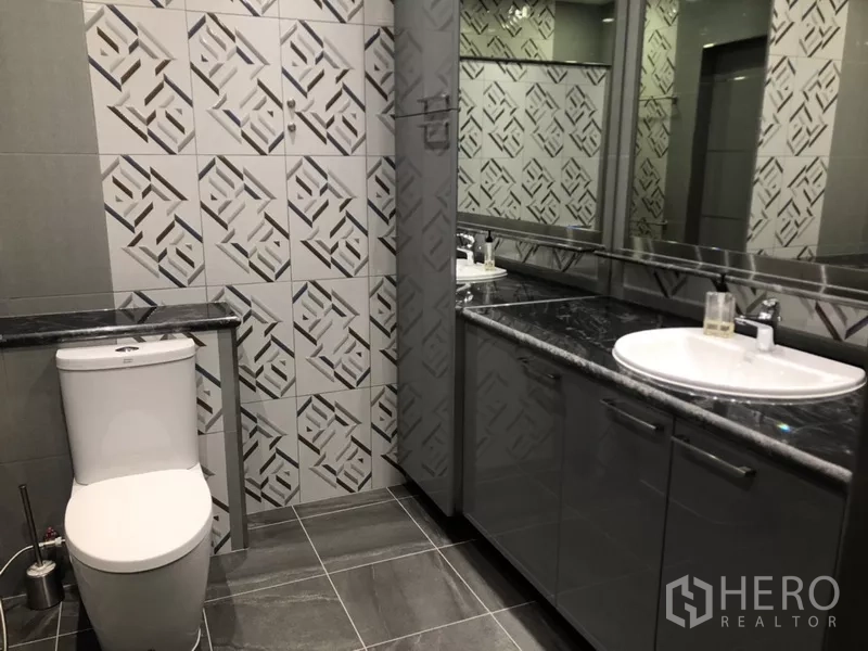 公寓 出租在Sathon, Bangkok - 第二卫浴设几何花纹墙砖、深色石材台面与浴室柜。
