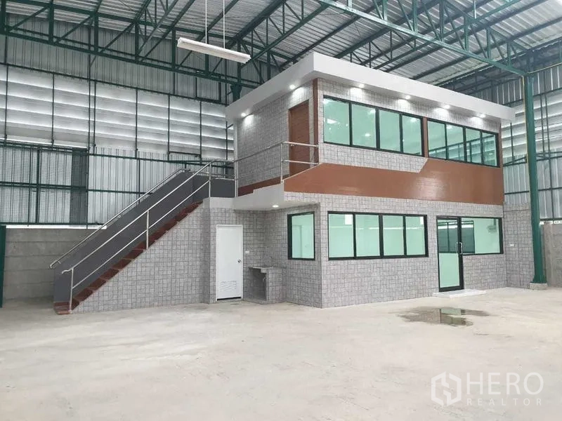 Warehouse for rent in Prawet, Bangkok - Close-up of the mezzanine office block inside the warehouse with stair access and lighting.