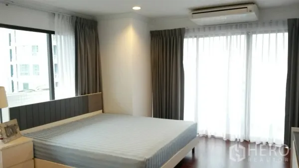 คอนโด ให้เช่าหรือขายในWatthana, Bangkok - ห้องนอนมุมอาคาร เตียงคิงไซส์ พร้อมประตูระเบียงและผ้าม่าน