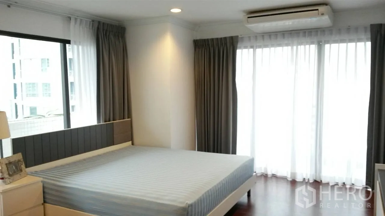 คอนโด ให้เช่าหรือขายในWatthana, Bangkok - ห้องนอนมุมอาคาร เตียงคิงไซส์ พร้อมประตูระเบียงและผ้าม่าน