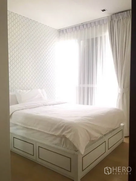 公寓 出租或出售在Watthana, Bangkok - 温馨卧室，几何纹理背景墙，带储物床与窗帘。