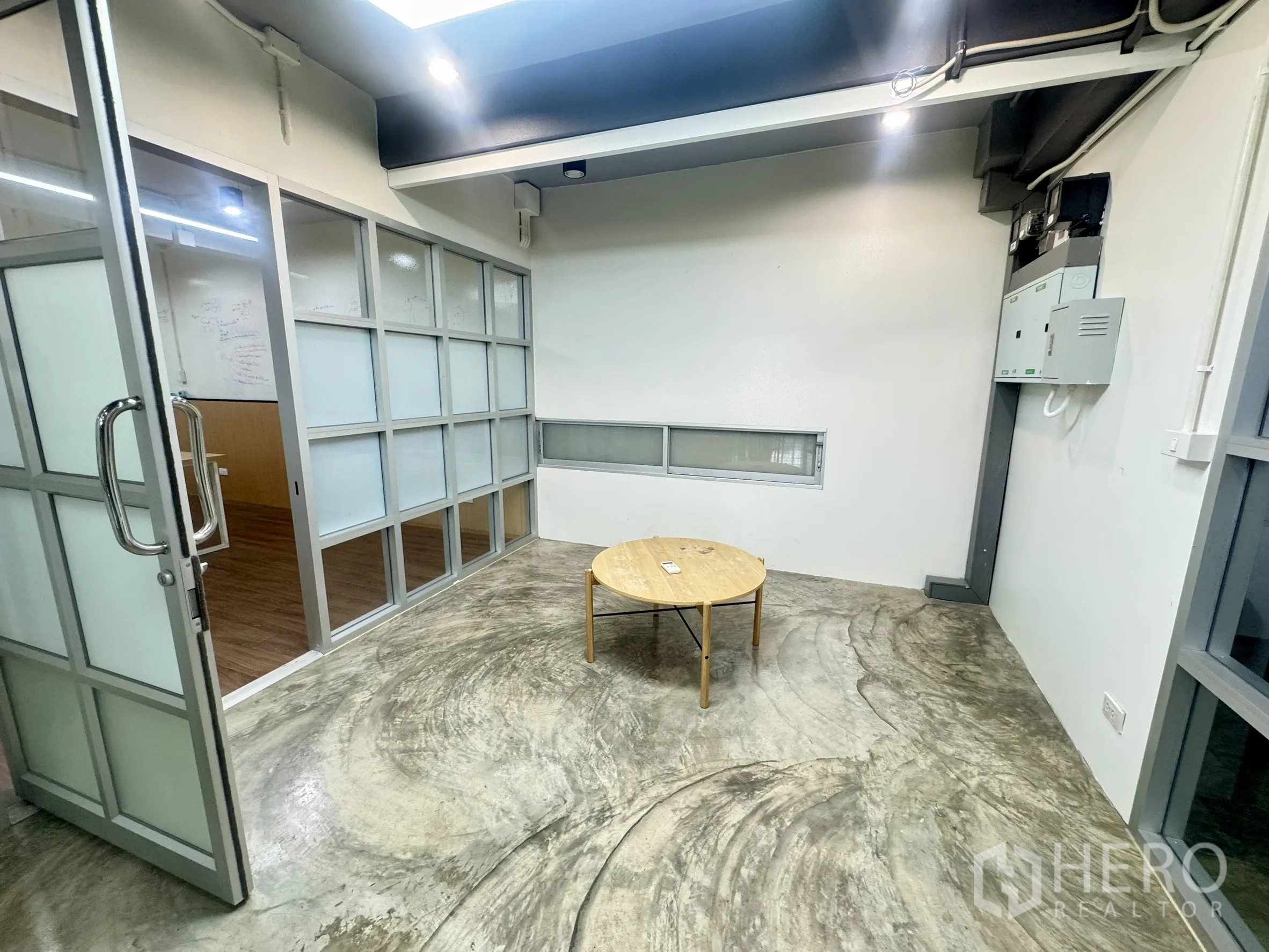 Office Space for rent in Bang Rak, Bangkok - Lounge or reception area with polished concrete floor and a round wooden coffee table.