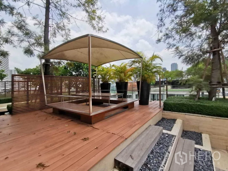 คอนโด ให้เช่าในWatthana, Bangkok - ดาดฟ้ากลางแจ้งพร้อมศาลาไวนิล โต๊ะนั่ง ต้นปาล์มกระถาง และสวนจัดแต่ง