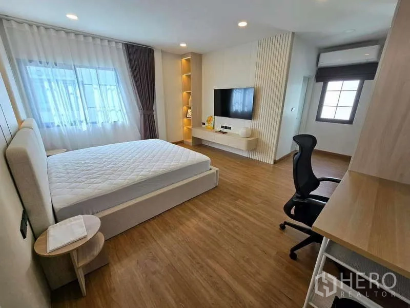 Detached House for rent in Bang Phli, Samut Prakan - Light-filled bedroom with built-ins, TV wall and work desk.