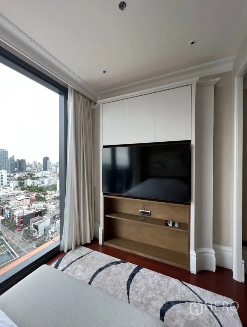 公寓 出租或出售在Watthana, Bangkok - 转角卧室，城市景观与内置电视墙。