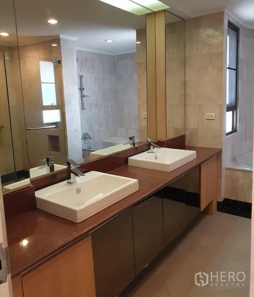 Condominium for rent in Watthana, Bangkok - Tiled bathroom featuring a long double vanity, large mirror and bathtub.