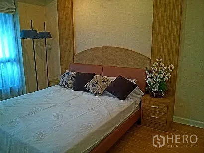 คอนโด ให้เช่าในPathum Wan, Bangkok - ห้องนอนหลักคอนโดปทุมวัน พร้อมหัวเตียงบุนุ่ม โต๊ะข้างเตียง และหน้าต่างผ้าม่านโปร่ง