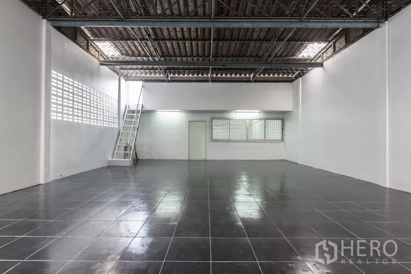 Home Office for sale in Bang Kho Laem, Bangkok - Large open-plan floor with dark tiles, high metal ceiling and a small mezzanine ladder.