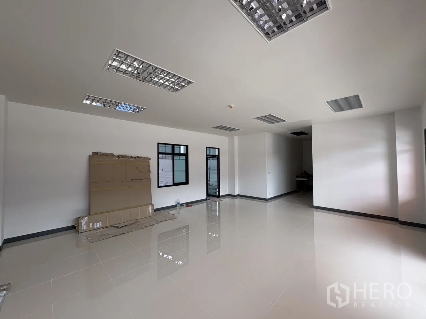 Factory for rent in Bang Pakong, Chachoengsao - Open-plan office area with fluorescent ceiling lights and windows.