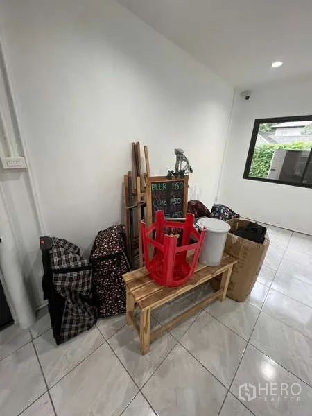 零售空间 出租在Khlong Toei, Bangkok - 后室，白墙、瓷砖地面与黑框窗户。