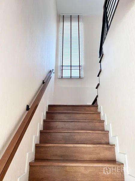 Detached House for rent or sale in Prawet, Bangkok - Wooden staircase with tall window and blinds.