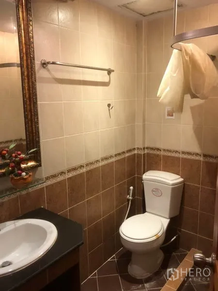 店屋 出租在Bang Rak, Bangkok - 瓷砖浴室，配坐便器、台面式洗手盆和手持喷枪。