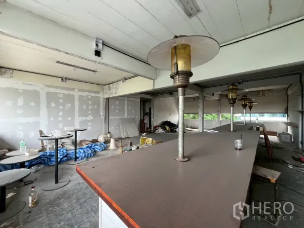 零售空间 出租在Watthana, Bangkok - 吧台与复古风灯具特写，墙面待修补的细节。