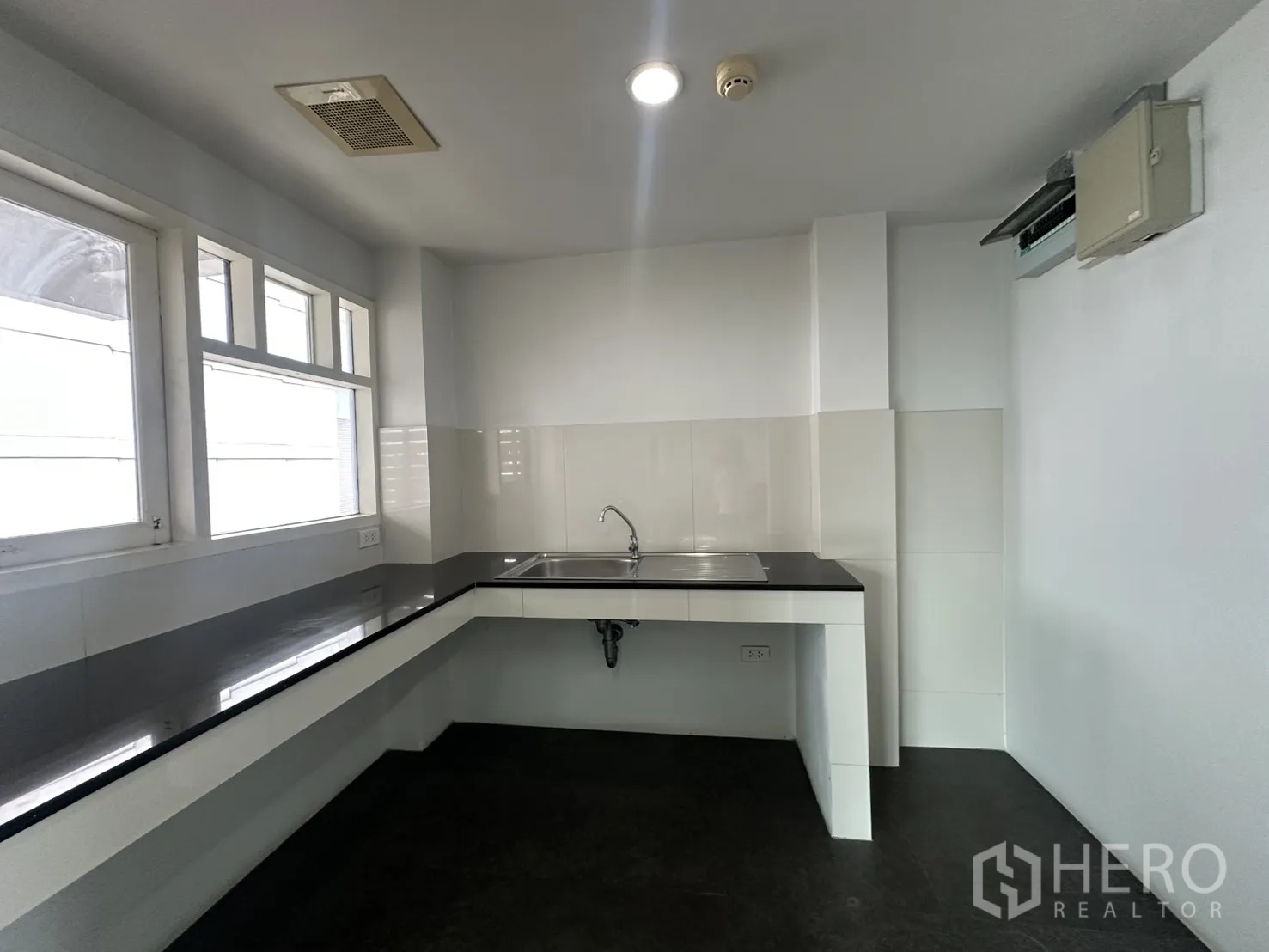 办公室 for rent in Watthana, Bangkok - 茶水间设长台面与水槽，带窗户采光。