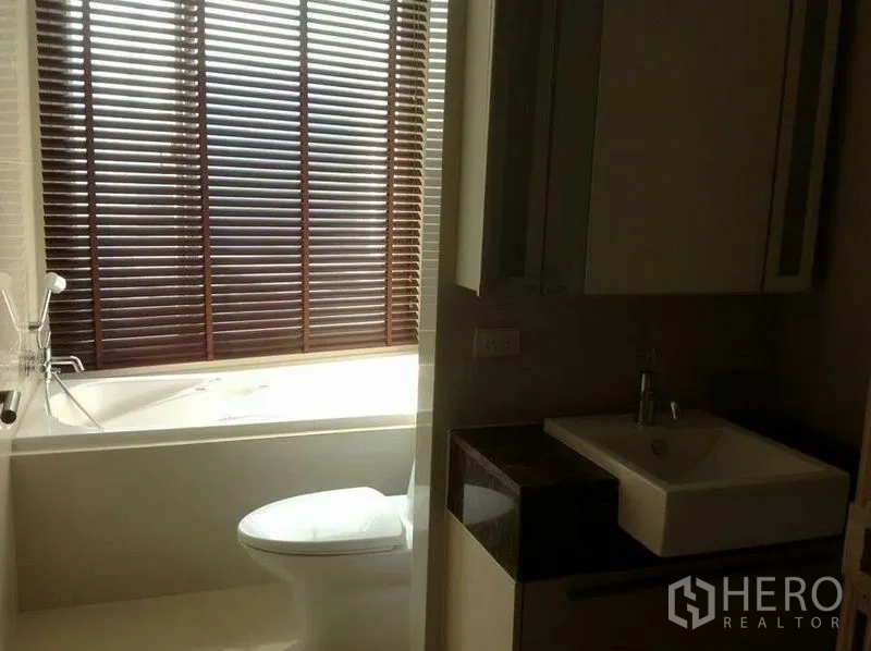 คอนโด ให้เช่าในWatthana, Bangkok - ห้องน้ำสมัยใหม่พร้อมอ่างอาบน้ำ โถสุขภัณฑ์ อ่างล้างหน้า และมู่ลี่ไม้รับแสงธรรมชาติ