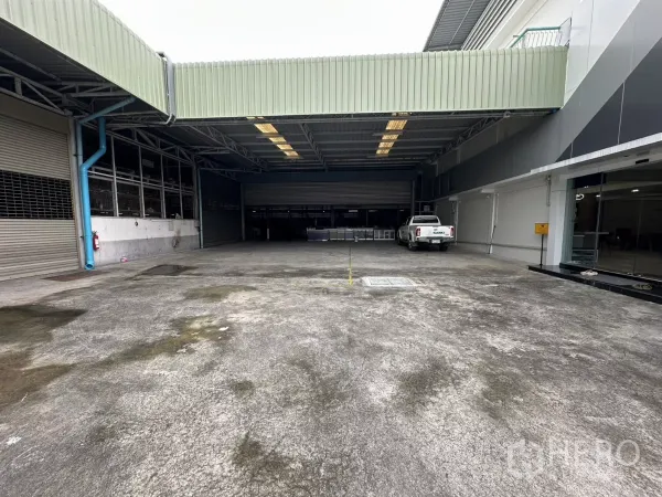 Warehouse for rent in Yan Nawa, Bangkok - Covered loading yard with roll-up doors and a pickup truck at a Bangkok warehouse.