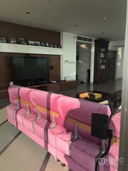 คอนโด ให้เช่าหรือขายในKhlong San, Bangkok - มุมนั่งเล่นพร้อมโซฟาตัวยาวสีชมพู โต๊ะกลาง และชั้นวางทีวีบิลท์อิน