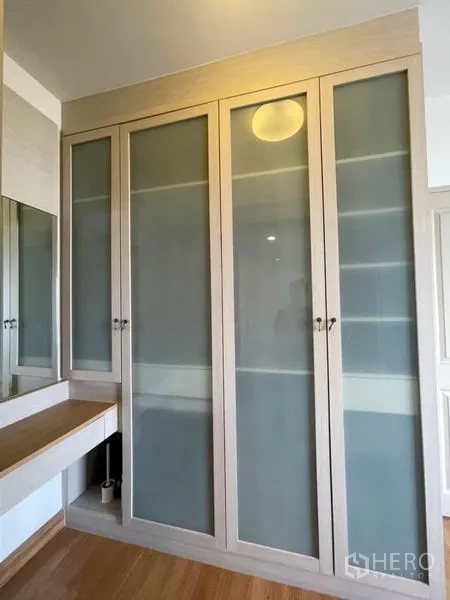 Condominium for sale - Built-in wardrobe with frosted glass doors and a dressing table.
