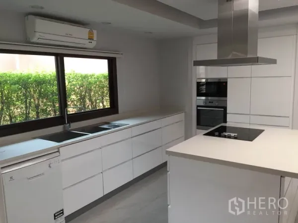 Detached House for rent in Sathon, Bangkok - Modern white kitchen with island, built-in oven, cooktop and range hood