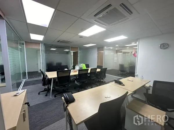 Office Space for rent - Workstation zone with conference table, cassette air-conditioning, and frosted glass meeting rooms.