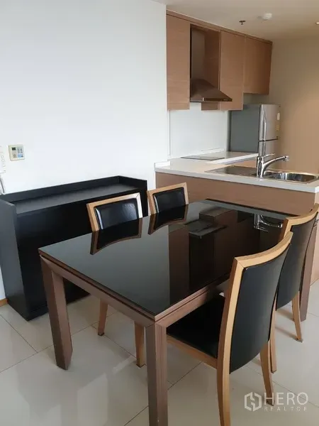 คอนโด ให้เช่าในKhlong Toei, Bangkok - ครัวแบบเปิดตู้ลายไม้ อ่างล้างจานสแตนเลส ตู้เย็น และโต๊ะอาหารท็อปดำเงา 4 ที่นั่ง