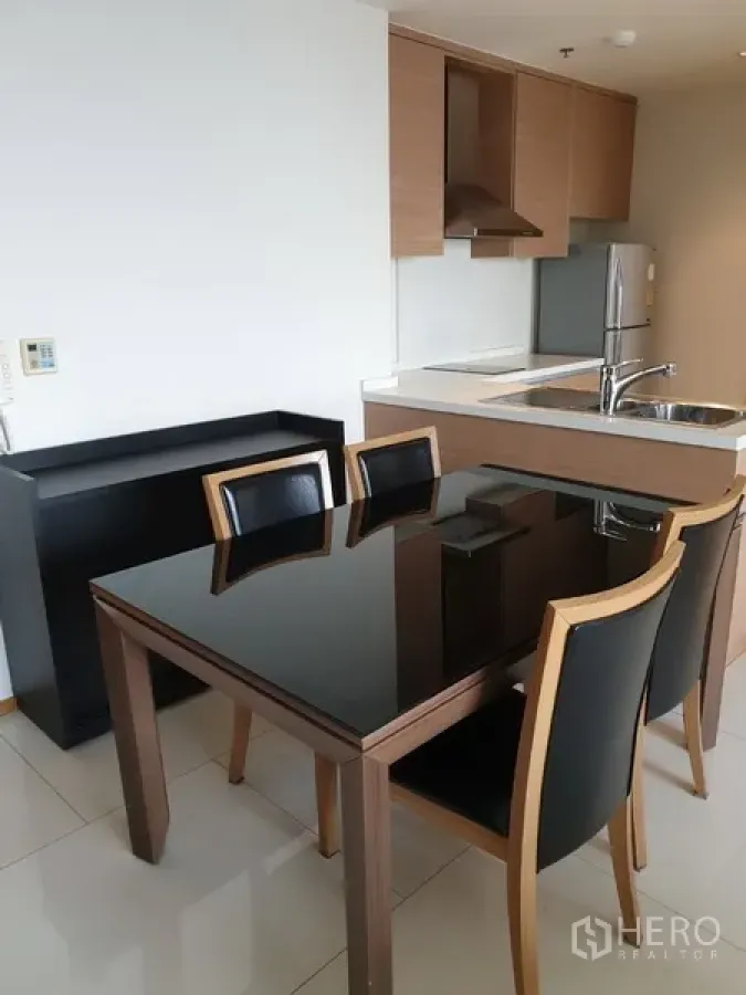 คอนโด ให้เช่าในKhlong Toei, Bangkok - ครัวแบบเปิดตู้ลายไม้ อ่างล้างจานสแตนเลส ตู้เย็น และโต๊ะอาหารท็อปดำเงา 4 ที่นั่ง