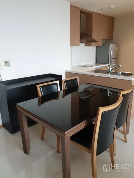 คอนโด ให้เช่าในKhlong Toei, Bangkok - ครัวแบบเปิดตู้ลายไม้ อ่างล้างจานสแตนเลส ตู้เย็น และโต๊ะอาหารท็อปดำเงา 4 ที่นั่ง