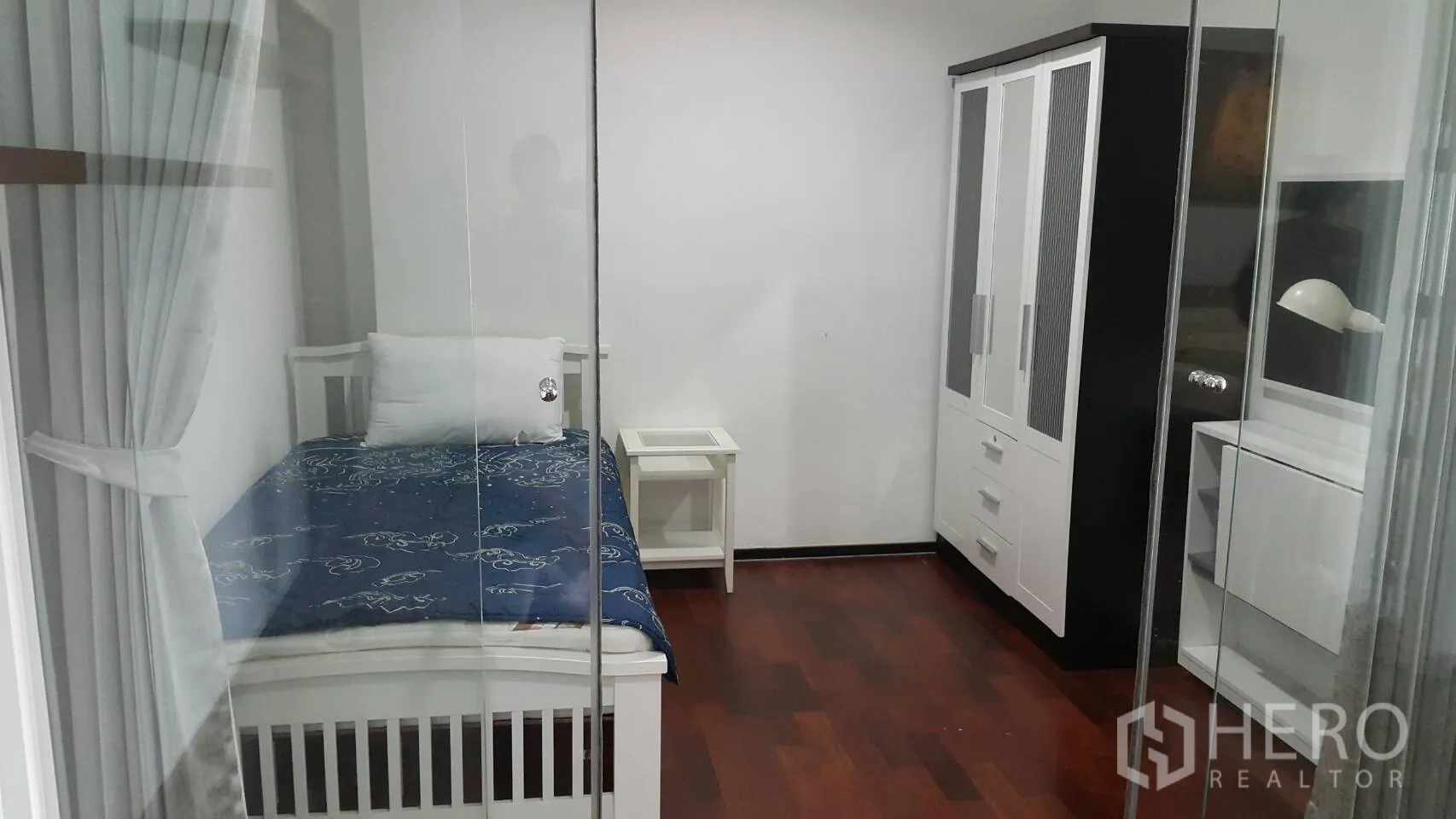 Condominium for rent in Watthana, Bangkok - Second bedroom with single bed, white wardrobe and glass sliding doors.