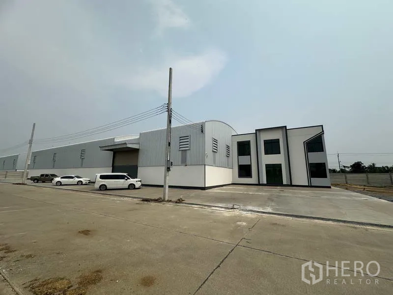 工厂 出租或出售在Sai Noi, Nonthaburi - 长条形仓库立面，带办公楼与停车位，临宽阔工业道路。