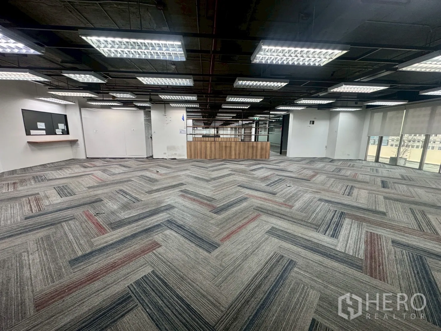办公室 for rent in Watthana, Bangkok - 大型工作区，地毯砖与明亮顶灯，中央设木质服务台。