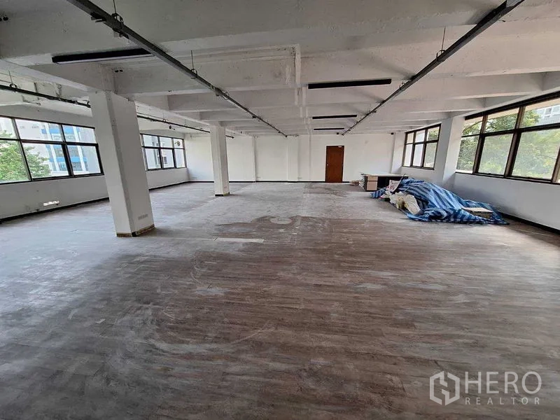 Office Space for rent in Watthana, Bangkok - Open office area featuring panoramic windows and concrete ceiling with lighting tracks.