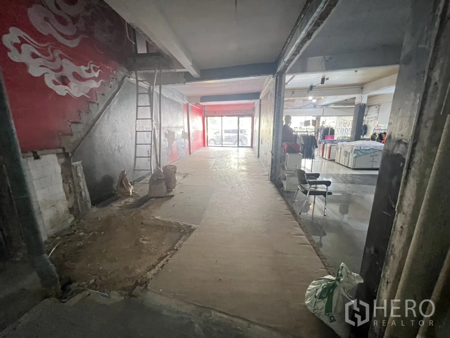 อาคารพาณิชย์ for rent in Khlong Toei, Bangkok - ภายในชั้นล่างตึกแถว ผนังดิบ บันไดคอนกรีต และหน้าร้านกระจกติดถนน