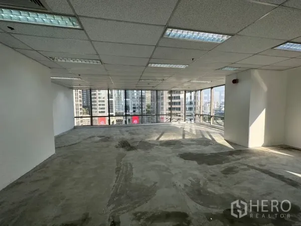 Office Space for rent - Bright corner office with wraparound glass windows and Bangkok skyline views.