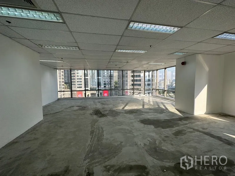 Office Space for rent - Bright corner office with wraparound glass windows and Bangkok skyline views.