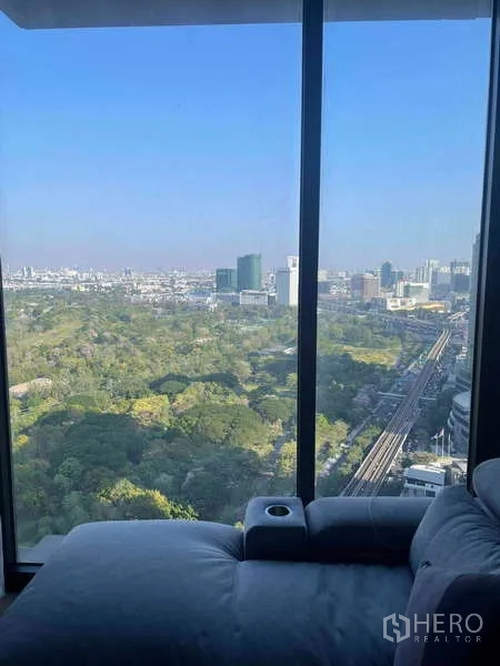 公寓 出租 - 落地窗旁的沙发，面向札都甲公园和轨道线景观。