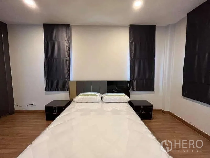Detached House for rent in Don Mueang, Bangkok - Bedroom headboard framed by twin windows with blackout drapes.
