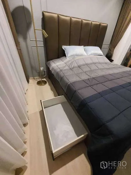 Condominium for rent - Bedroom with under-bed storage drawer and floor lamp by the window.