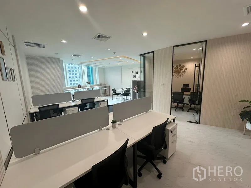 Office Space for rent - Open‑plan workstations with partitions facing glass‑walled office and window bar.